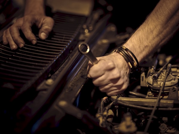 Mechanic using a wrench in a vehicle engine bay