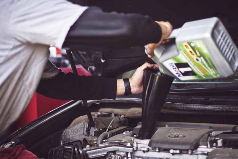 Mechanic working in the engine bay of a car in a repair shop